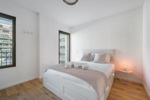 Un dormitorio blanco con una cama y una ventana. en GuestReady – Steps from Estádio do Dragão, en Oporto