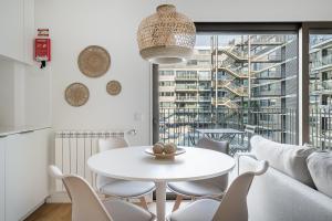 Un comedor blanco con una mesa y sillas blancas. en GuestReady – Steps from Estádio do Dragão, en Oporto