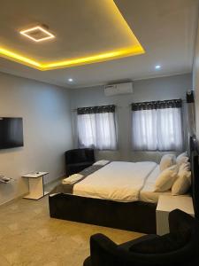 a bedroom with a large bed and a flat screen tv at Folulakes Regal Villas in Ibadan