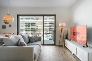 Una sala de estar con un sofá y un televisor. en GuestReady – Steps from Estádio do Dragão, en Oporto