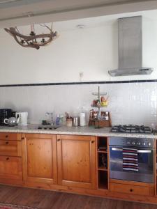 cocina con armarios de madera y fogones en Greenwoods cottage en Valkenburg
