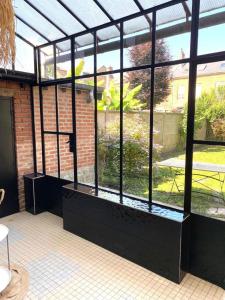 a room with a window with a view of a garden at La maison du voyageur toque in Charleville-Mézières
