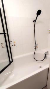 a shower with a blow dryer on top of a bath tub at La maison du voyageur toque in Charleville-Mézières