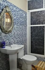 a bathroom with a sink and a toilet and a mirror at Gîte Ayour Atlas Tachddirt in Tacheddirt