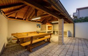 a wooden bench sitting on a patio under a roof at Villa Sunrise in Lopar