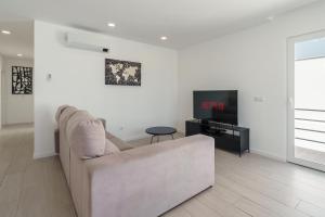 a living room with a couch and a tv at Villa Paradise 2 in Santa Barbara
