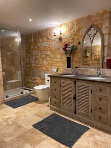 a bathroom with two sinks and a shower and a toilet at Maison de la Combe in Domme