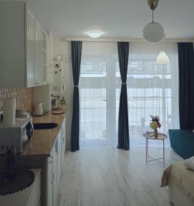 a living room with a kitchen with a microwave at Saturn ROOMS in Saturn