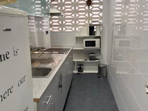a kitchen with a sink and a microwave at Apartamento Pineda de Mar en Primera Línea in Pineda de Mar +2 photos