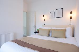 a bedroom with a large white bed with two pillows at 3 Bed Modern Cottage near Hiking Trails & Parks in Llwyn-y-pia