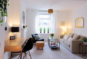 a living room with a couch and a table at 3 Bed Modern Cottage near Hiking Trails & Parks in Llwyn-y-pia