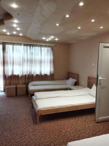 a room with two beds and a window at Стаи за гости Деметра in Sofia