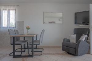 a living room with a table and a chair at Holiday apartments by the sea in Funtana