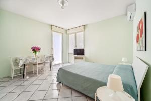a bedroom with a bed and a table in it at Green Village Accommodations in Colico