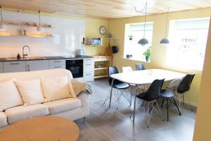 a living room with a white couch and a table at Colorful brand new apartment with free parking in Tórshavn