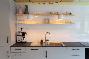 a kitchen with a sink and a counter top at Colorful brand new apartment with free parking in Tórshavn +24 photos