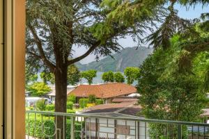 a view from a balcony of a house with a tree at Green Village Accommodations in Colico