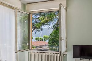 an open window with a view of a mountain at Green Village Accommodations in Colico