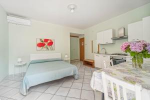 a kitchen and a bedroom with a bed and a table at Green Village Accommodations in Colico