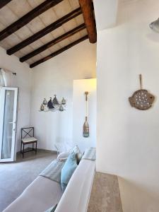 a living room with white walls and a couch at Blue Eden La Maddalena in La Maddalena +77 photos
