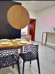 una mesa de comedor y 2 sillas con platos. en Apartamento no centro de Tatuí 2, en Tatuí