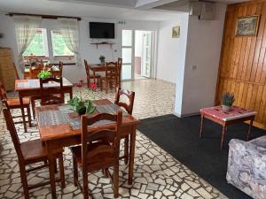 a dining room with wooden tables and chairs at Pensiunea Flora TransFăgărășan in Cumpăna