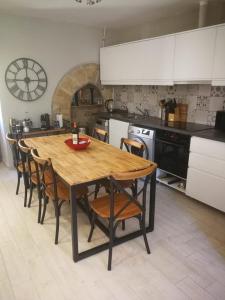 a kitchen with a wooden table and chairs at Maison de la Combe in Domme