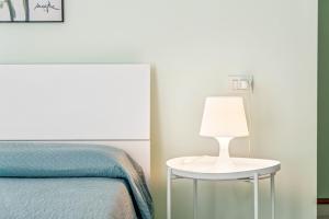 a bedroom with a bed and a table with a lamp at Green Village Accommodations in Colico