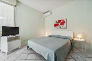 a bedroom with a bed and a flat screen tv at Green Village Accommodations in Colico