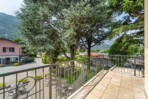a balcony with a tree and a fence at Green Village Accommodations in Colico