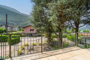 a balcony with a fence and a tree at Green Village Accommodations in Colico