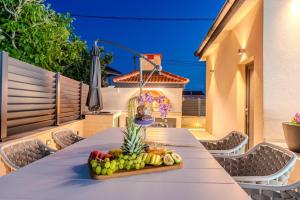 a tray of fruit on a table on a patio at Villa Ballat with heated pool in Privlaka