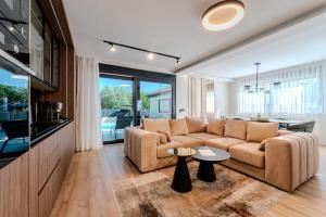 a living room with a couch and a table at Villa Ballat with heated pool in Privlaka