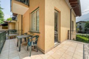 a patio with a table and chairs on a balcony at Green Village Accommodations in Colico