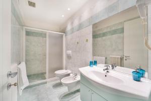 a bathroom with a sink and a toilet and a shower at Green Village Accommodations in Colico