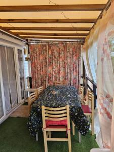 a dining room with a table and chairs and a curtain at Les sables du midi in Valras-Plage