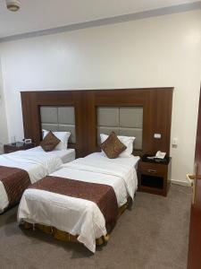 a hotel room with two beds and a telephone at نزل اكنان للشقق المخدومة in Najran