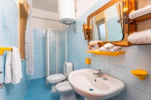 un bagno con lavandino, WC e specchio di I Ciottoli Dello Ionio a Mascali Altre 170 foto