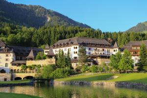 un resort con lago e montagne sullo sfondo di Schlosshotel Kitzbühel A-ROSA Collection a Kitzbühel