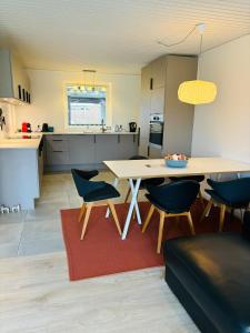 Una cocina y una sala de estar con mesa y sillas. en Modern house in Billund, en Billund