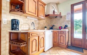 a kitchen with wooden cabinets and a white dishwasher at Charmante Maison À La Campagne in Saint-Martial-de-Valette