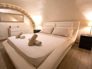 Una cama blanca grande con dos toallas encima. en Suite House 78, en Bari