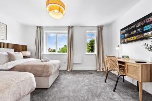 Una habitación de hotel con una cama y un escritorio y un escritorio. en Spacious 4BR Home, Garden & Parking, Sleeps 8, en Brimsdown Station