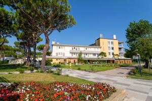 a person walking in front of a building with flowers at Villaggio San Paolo in Cavallino-Treporti