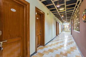 a hallway with wooden doors and a tile floor at Super Hotel O Santushti in Dewās