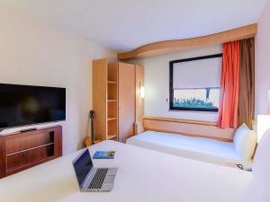 a hotel room with a bed and a laptop on a desk at Hotel Ibis Lisboa Sintra in Sintra