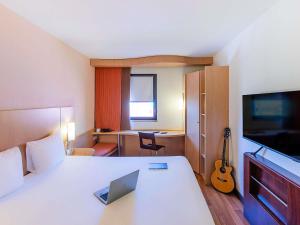 a hotel room with a bed with a laptop on it at Hotel Ibis Lisboa Sintra in Sintra +37 photos
