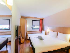 a hotel room with a bed and a laptop on it at Hotel Ibis Lisboa Sintra in Sintra