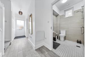 Un baño blanco con ducha y WC. en Spacious 4BR Home, Garden & Parking, Sleeps 8, en Brimsdown Station 51 fotos más