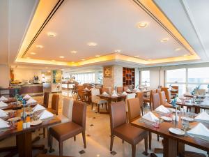 a dining room with wooden tables and chairs at Grand Mercure Majlis Residences in Abu Dhabi